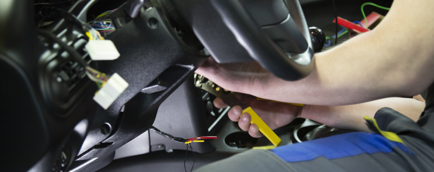 Mechanic checking the electrics under the steering wheel - Auto Electrics in Weston-super-Mare